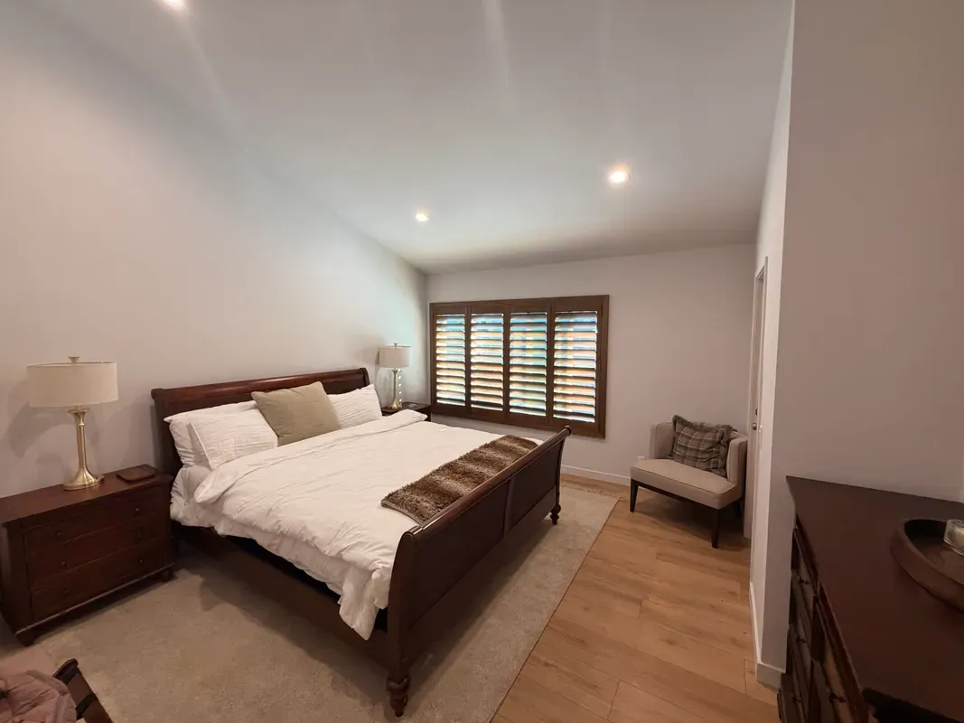 Dark wood blinds in a master bedroom